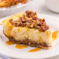 A slice of caramel pecan cheesecake on a plate.