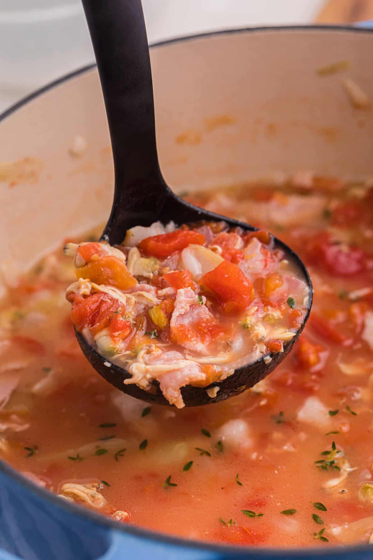 A ladle with Manhattan Clam Chowder.