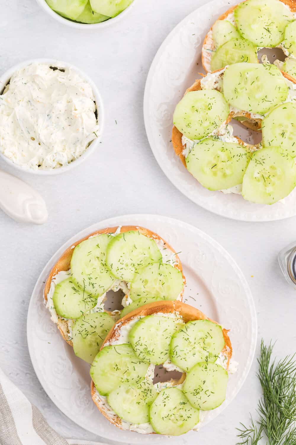 Dilly bagels served on white plates.