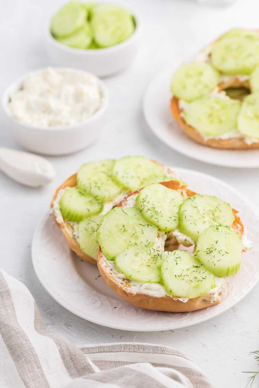 Dilly bagels served on white plates.