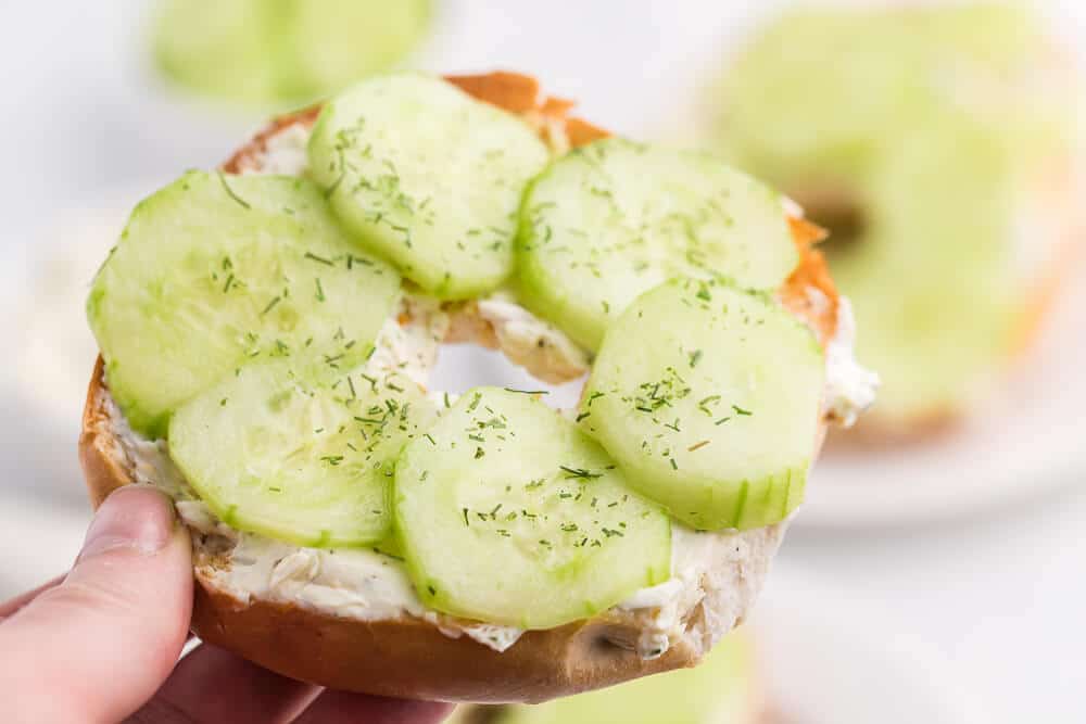 A hand holding a dilly bagel.