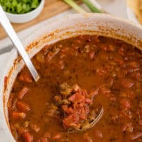 The soup in a pot with a ladle.