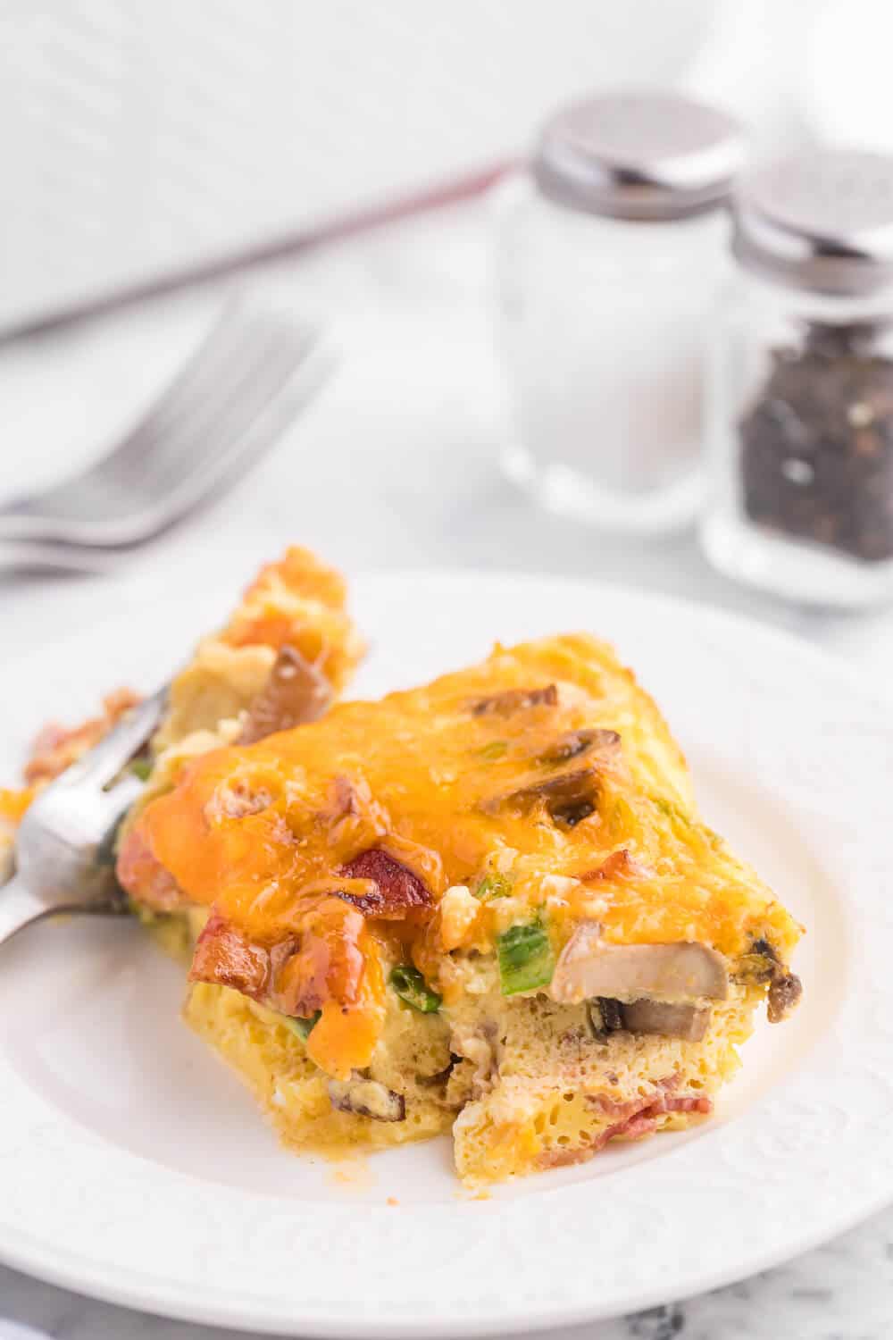 Crustless Bacon and Cheese Quiche - Rich, creamy eggs with bacon and cheese are a fantastic, lower carb option for brunch or dinner. Served with fruit or mixed greens, this is delicious and satisfying, no matter what time of day you make it!