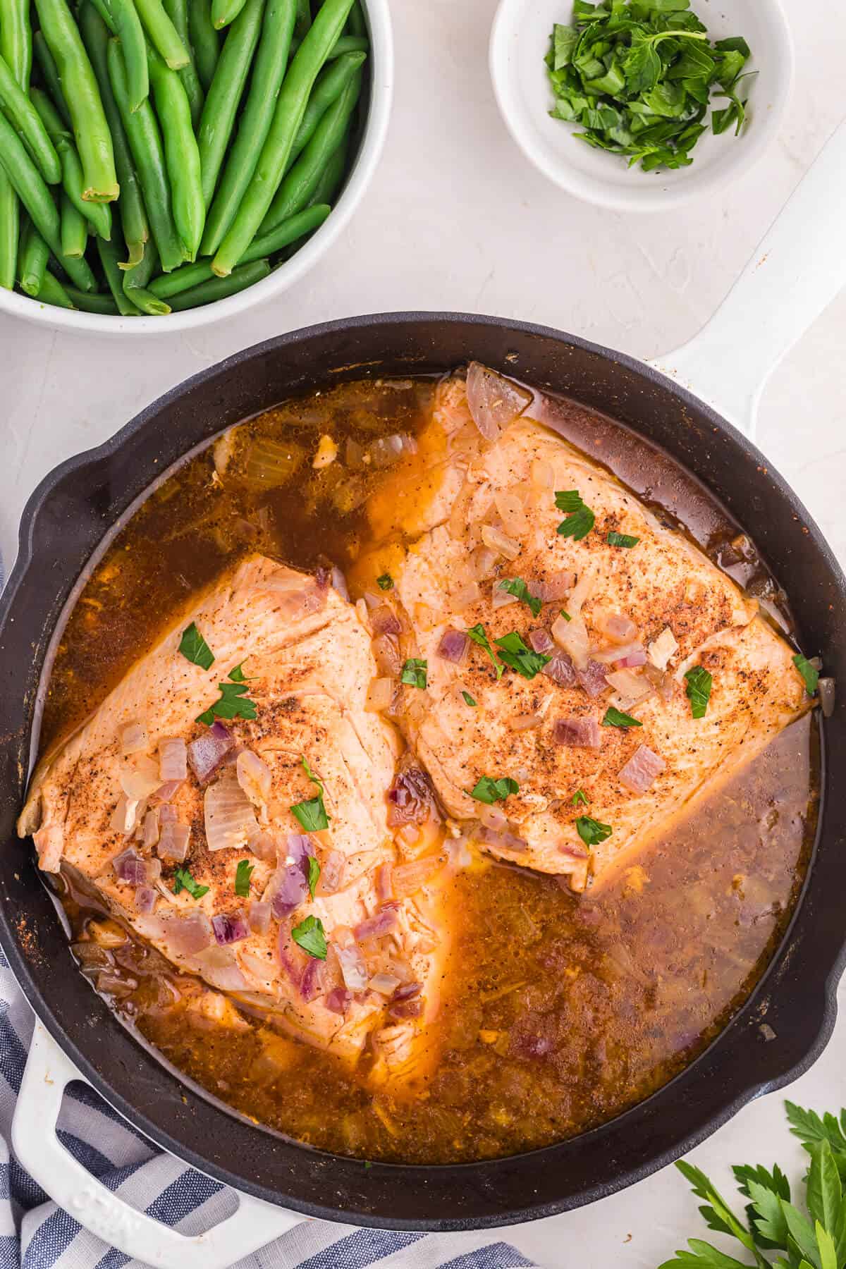 Salmon fillets in a skillet with beer sauce.