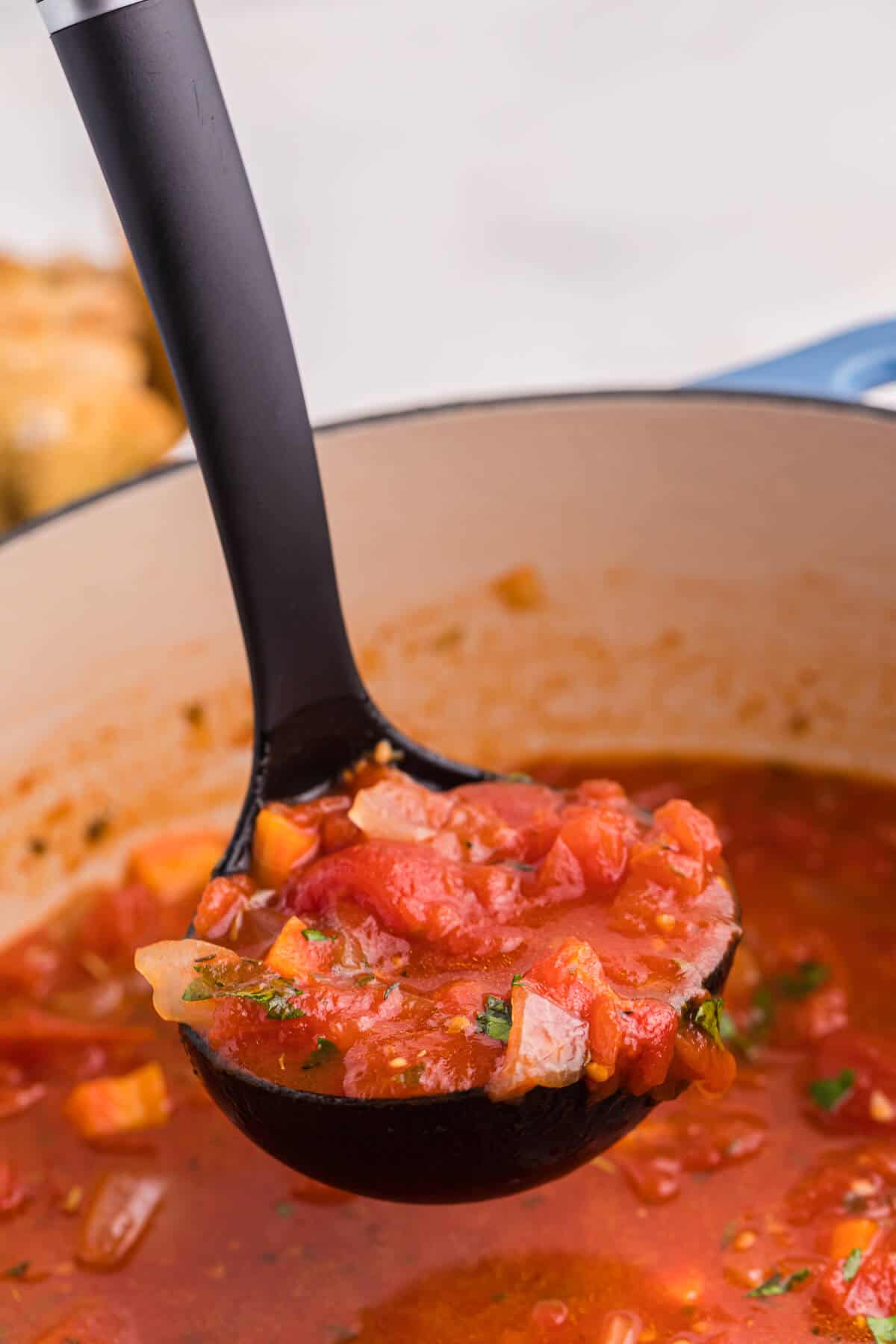 Italian Herb Soup in a black ladle.