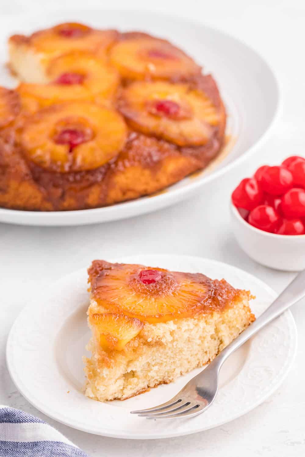 A slice of pineapple upside down cake on a white plate