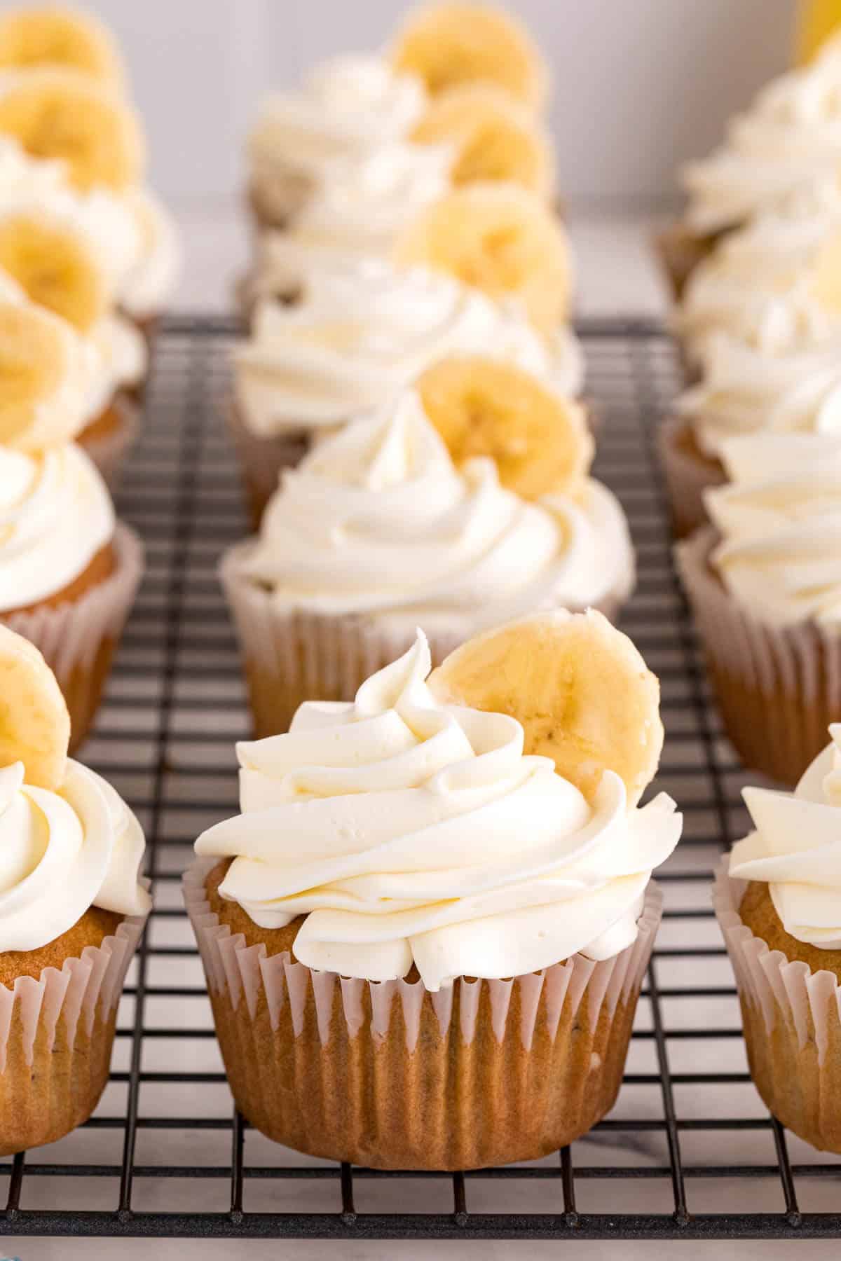 Banana cupcakes on a wire rack.