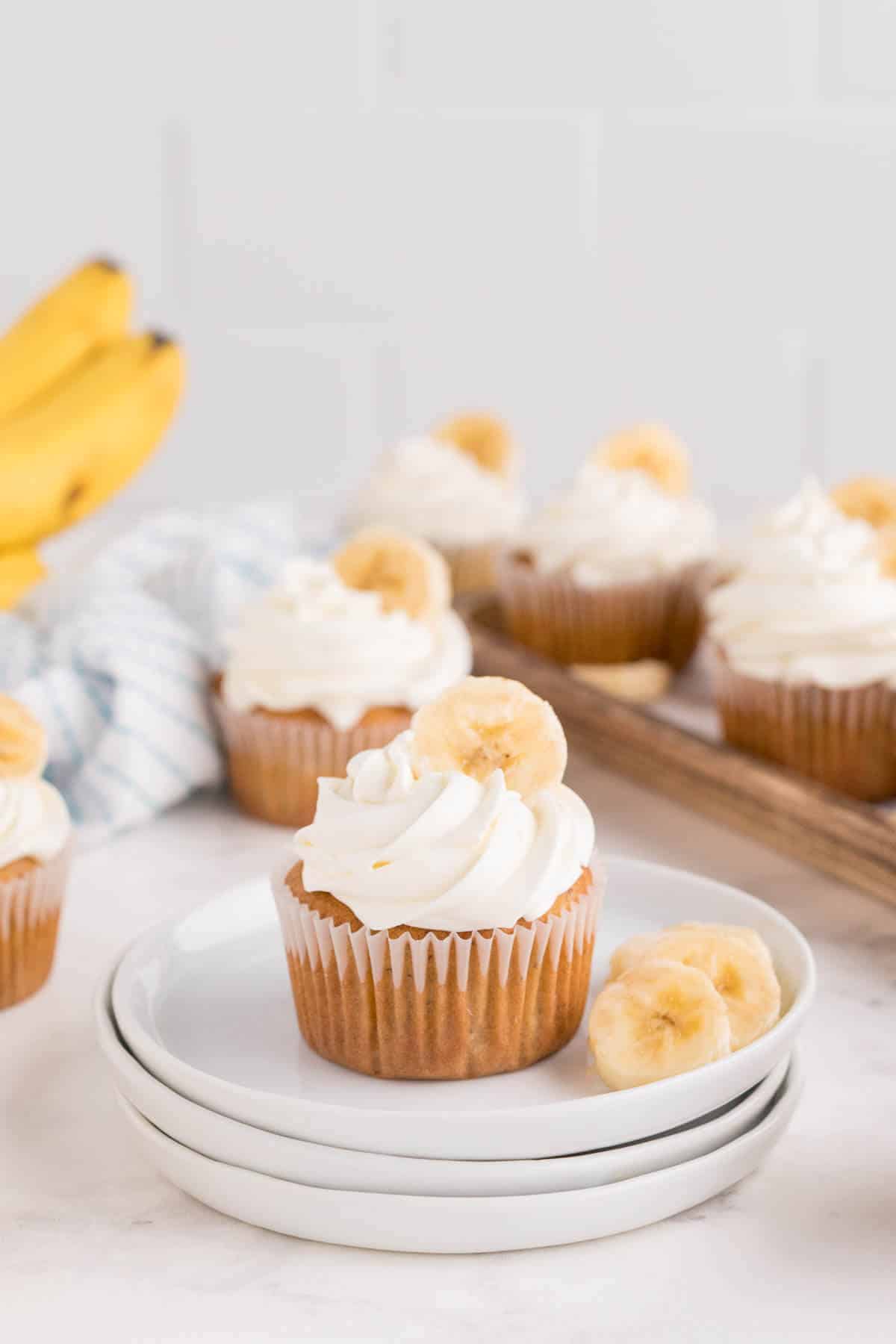 Banana cupcakes on a plate with banana slices.