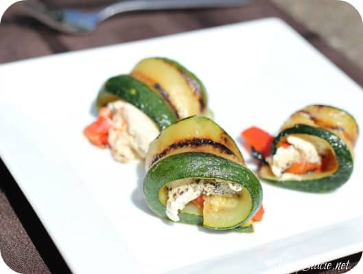 Grilled Zucchini Roll-Ups - A simple, but savory summer appetizer. This easy recipe wraps grilled zucchini strips around herbed goat cheese and grilled red peppers with a finish of extra olive oil and balsamic vinegar. Mmm!