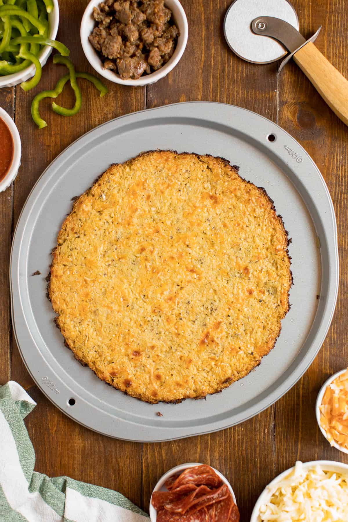 A cauliflower pizza crust on a pizza pan.