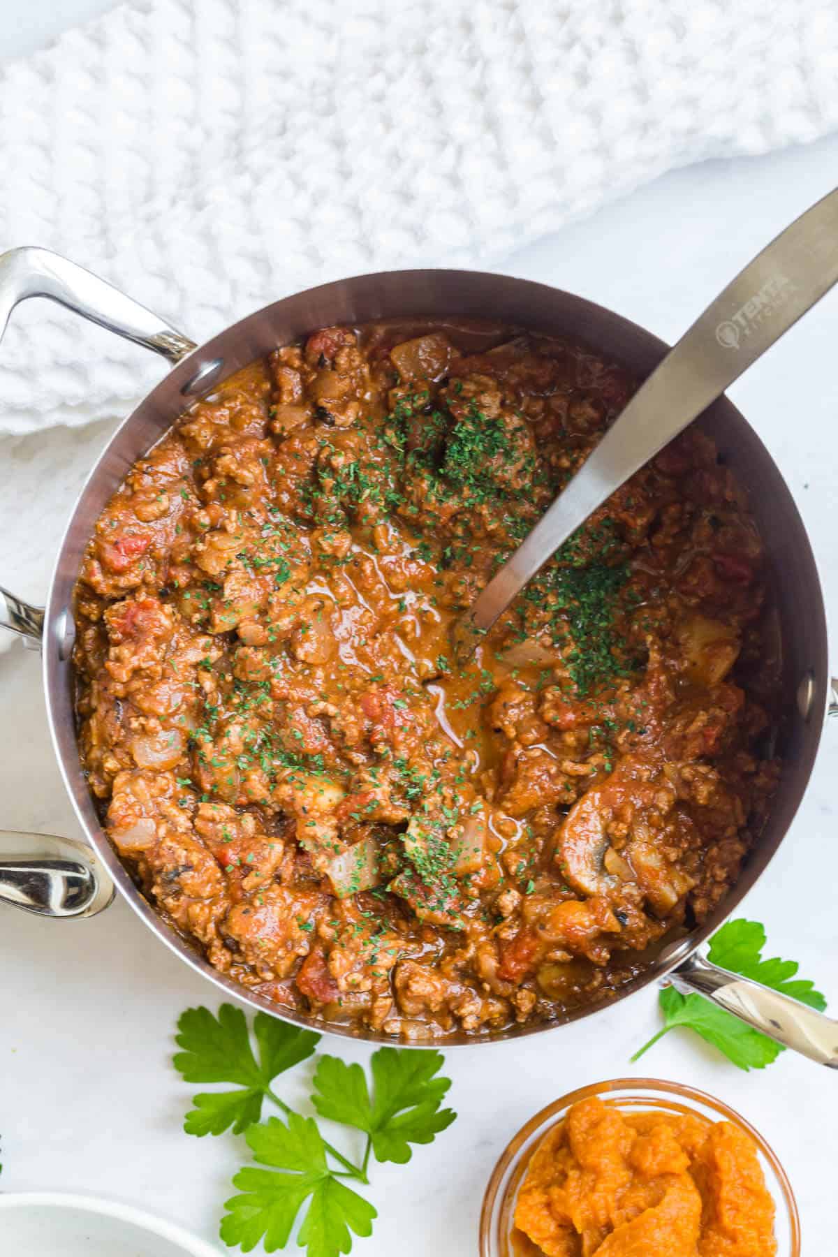 Pumpkin chili in a pot with a ladle.