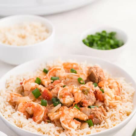 Sausage jambalaya in a bowl over a bed of rice.