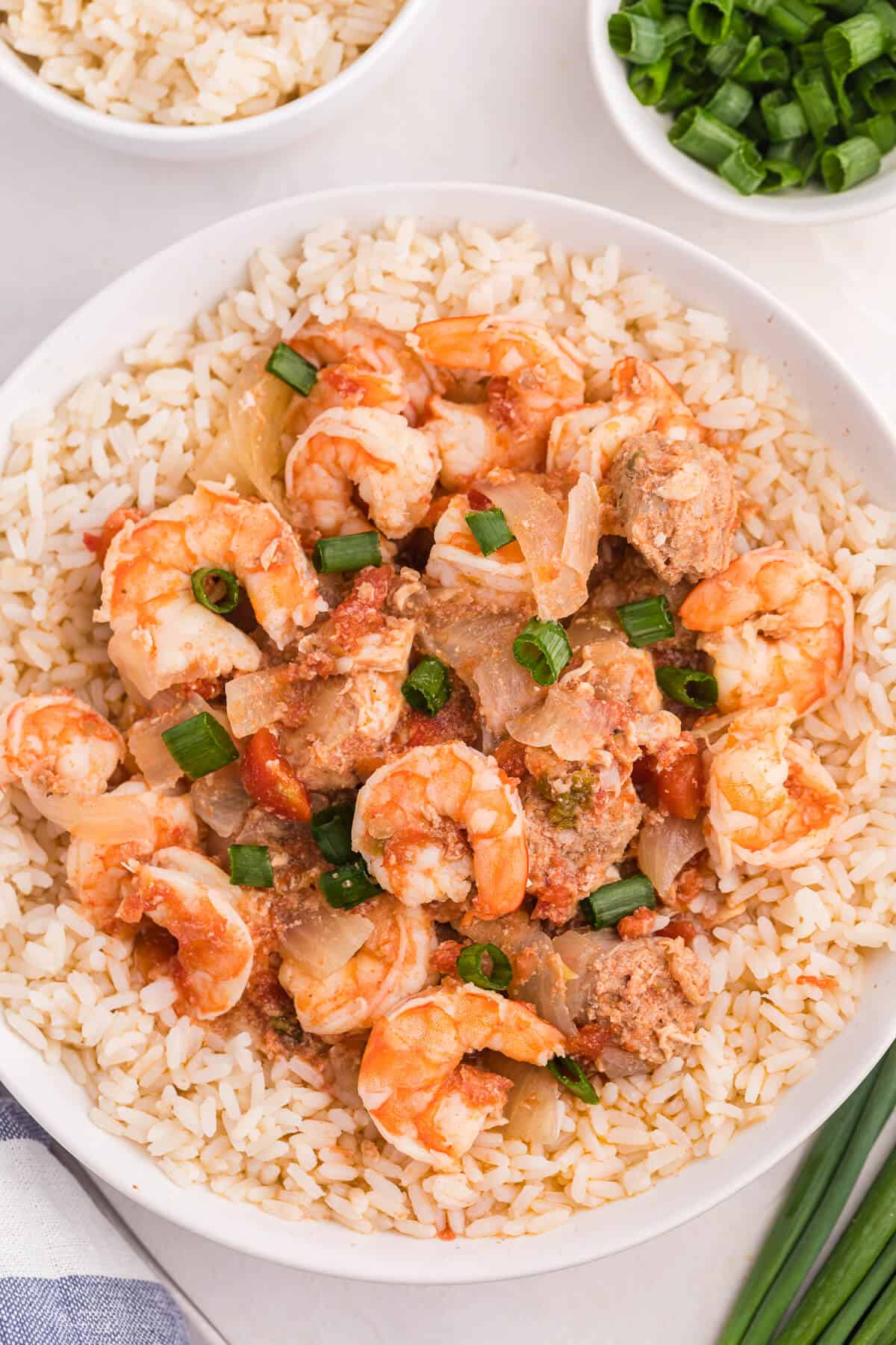 Sausage jambalaya over a bed of rice in a bowl.