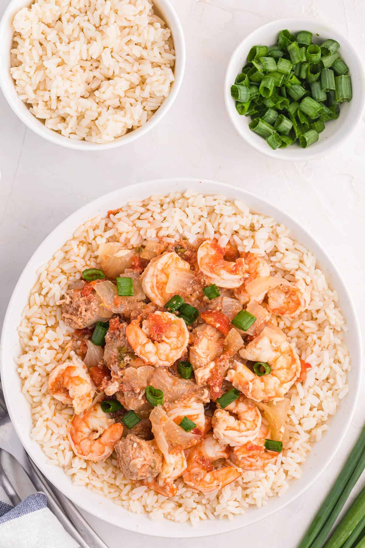 Sausage jambalaya over rice in a bowl.