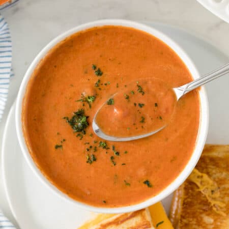 Cream of Tomato Soup in a bowl with a spoon.