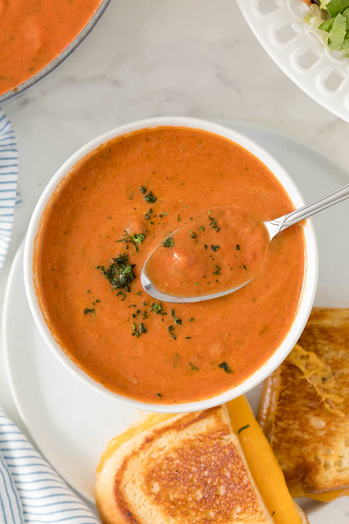 Cream of Tomato Soup in a bowl with a spoon.