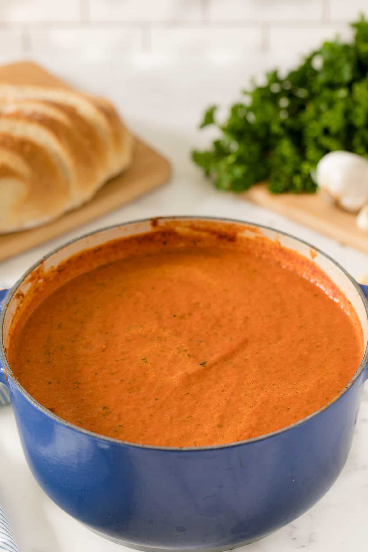a blue dutch oven filled with cream of tomato soup.