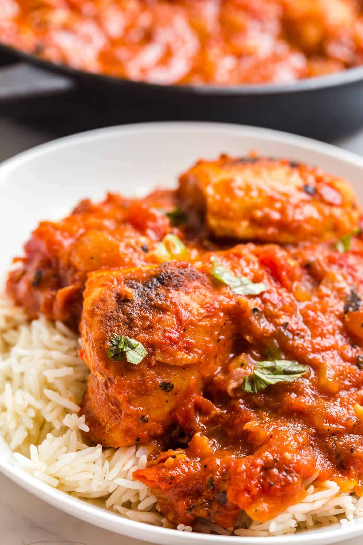 Roasted red pepper chicken on plate served over rice.