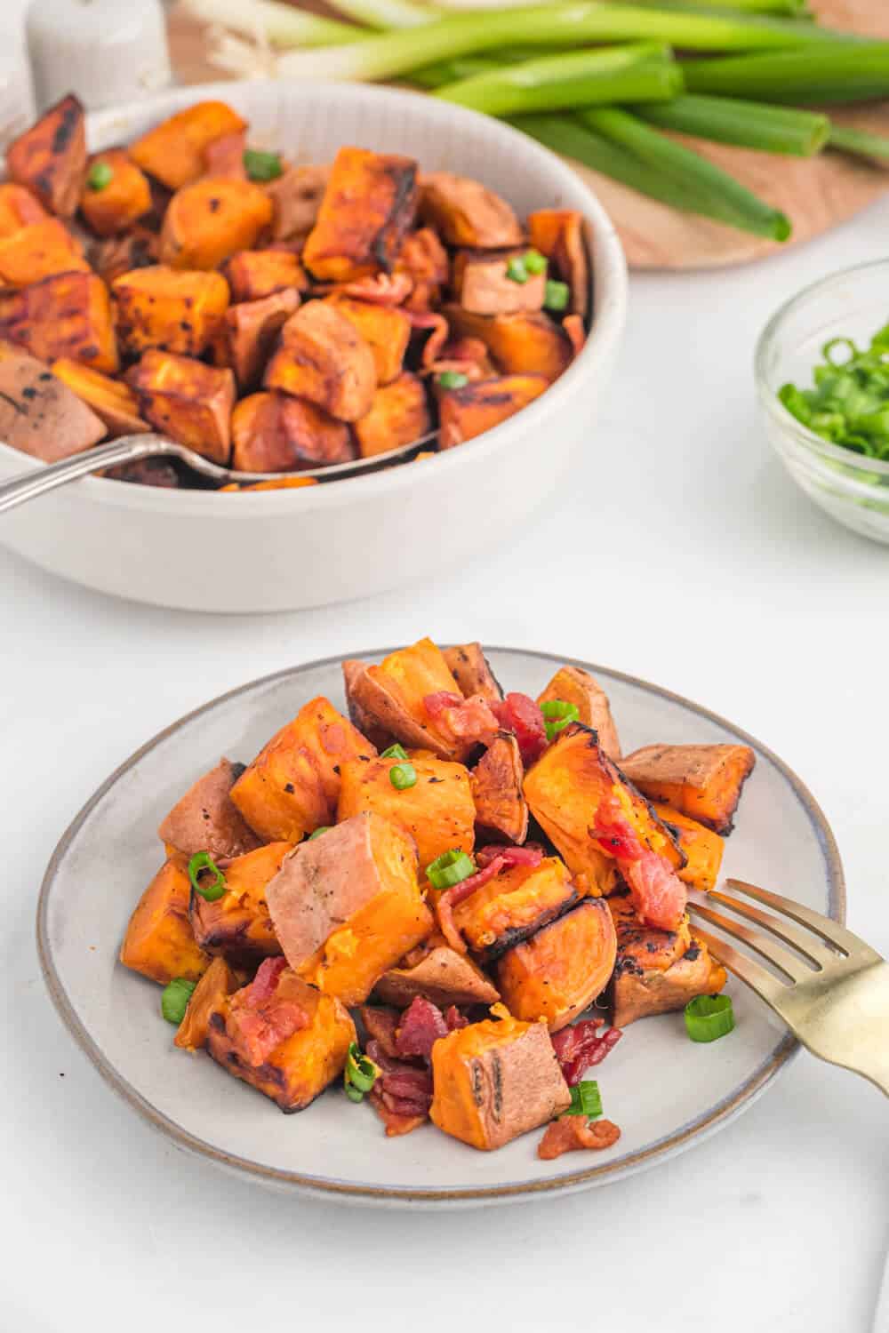 Sweet potato home fries on a plate with a fork.