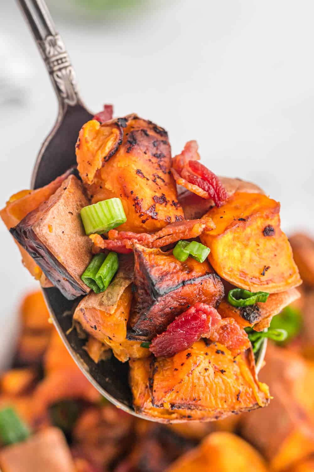 Sweet potato home fries on a spoon.