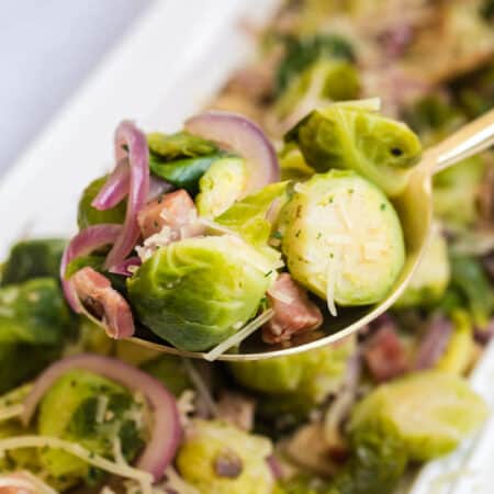 Brussel sprouts with lemon and pancetta on a serving spoon.