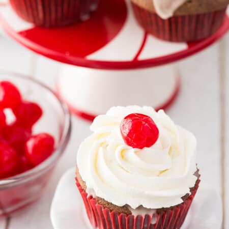 Cherry Coke Cupcakes - Each cupcake has a cherry in the middle, glazed with a Coca-Coca sugar glaze and topped with sweet and fluffy whipped cream.