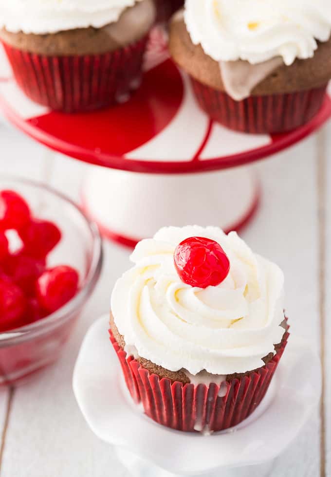 Cherry Coke Cupcakes - Each cupcake has a cherry in the middle, glazed with a Coca-Coca sugar glaze and topped with sweet and fluffy whipped cream. 