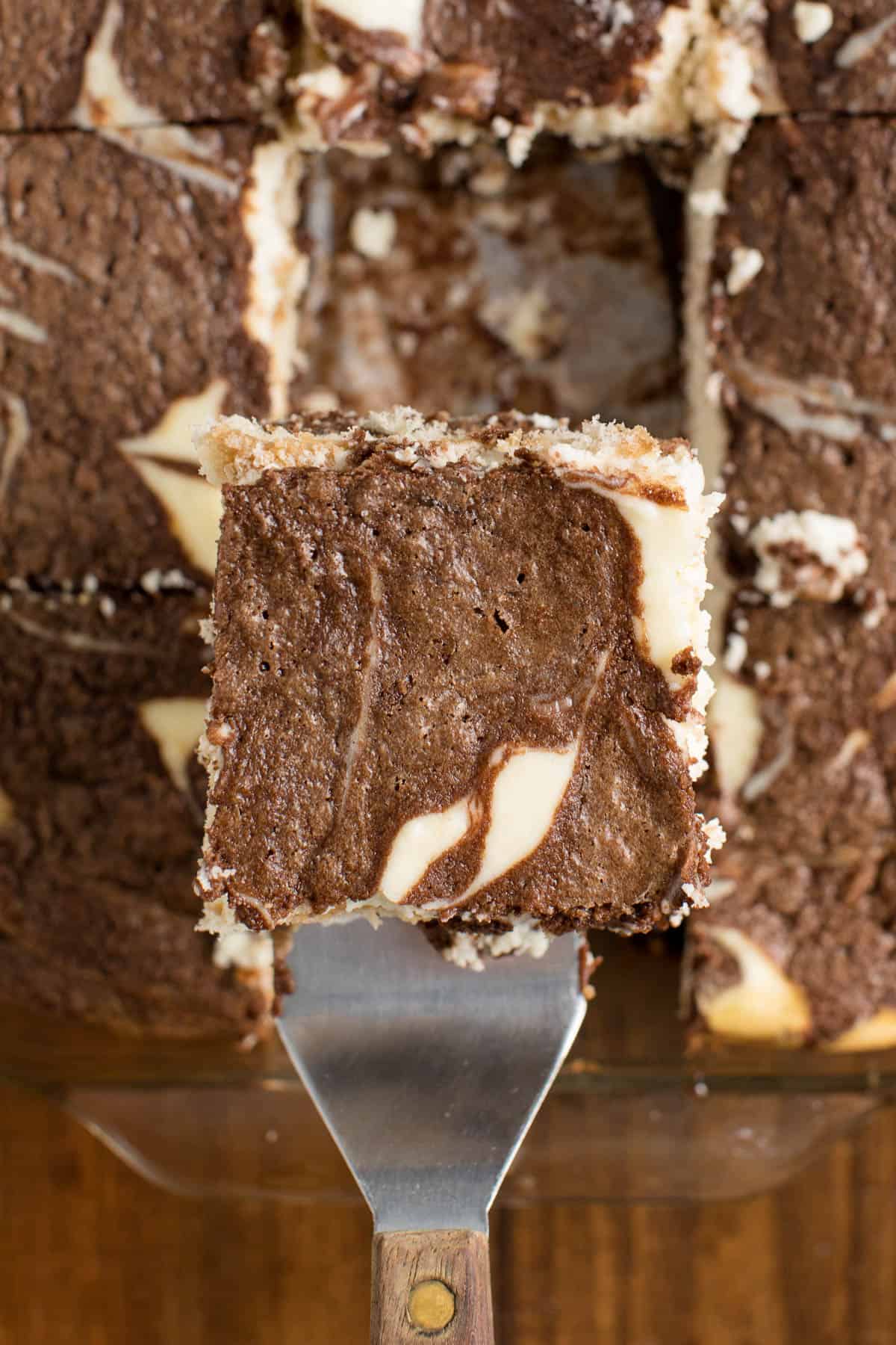 photo of a cut piece of tiramisu brownies on a serving spatula