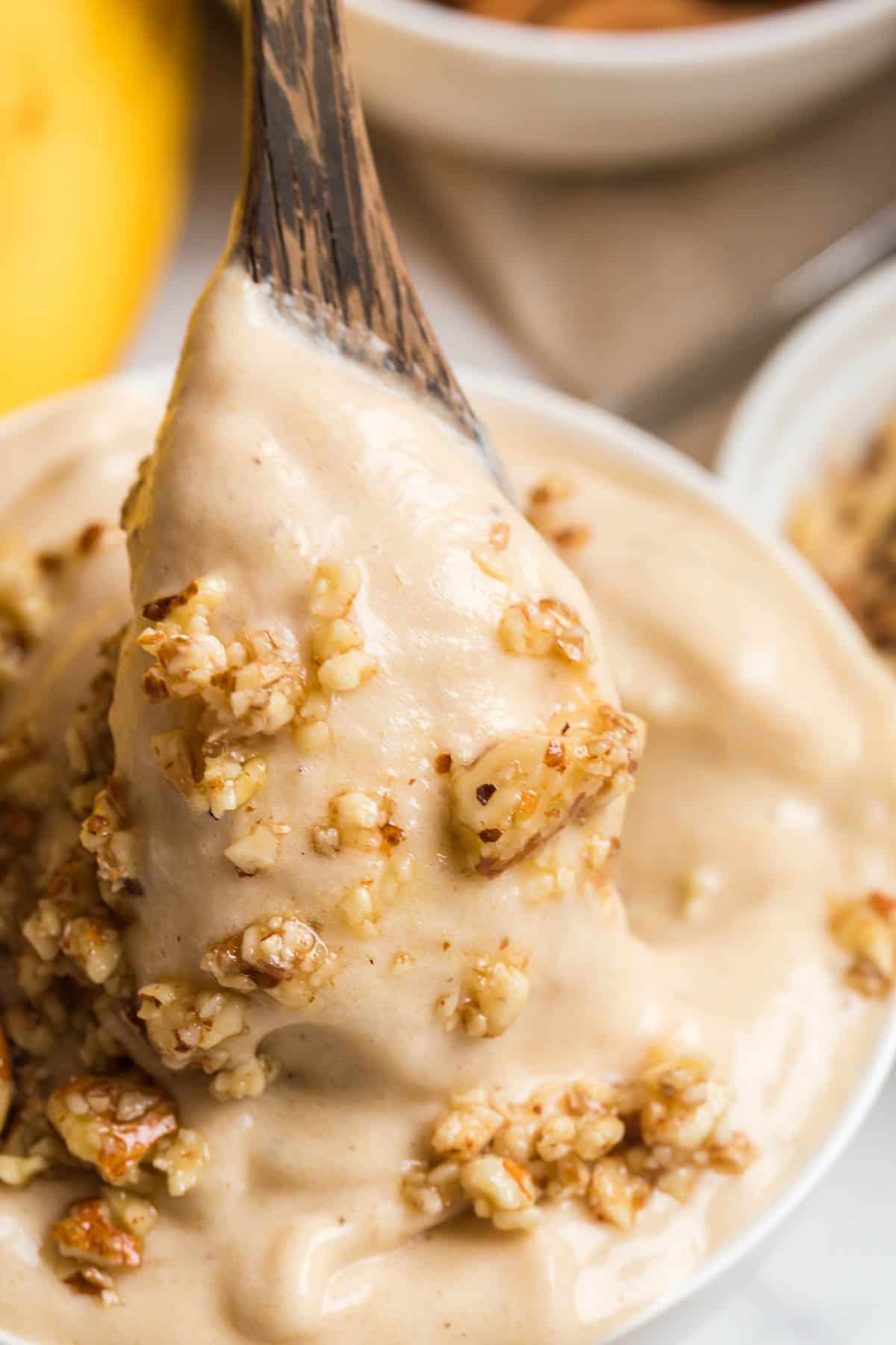 Dairy free banana ice cream on a spoon in a bowl.