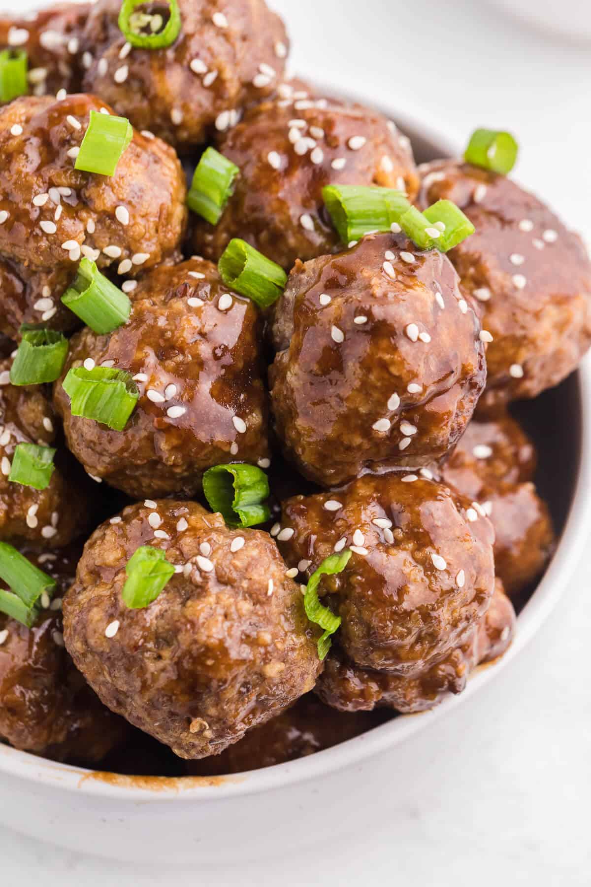 Ginger Meatballs - Add this Asian meatball recipe to your next party menu! Homemade beef meatballs with zesty ginger are smothered in sweet and tangy stir fry sauce. Yum!