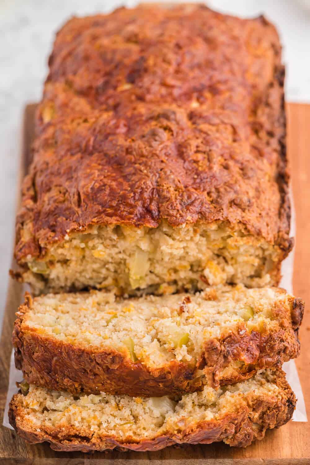 A loaf of apple cheddar bread with slices cut on the end