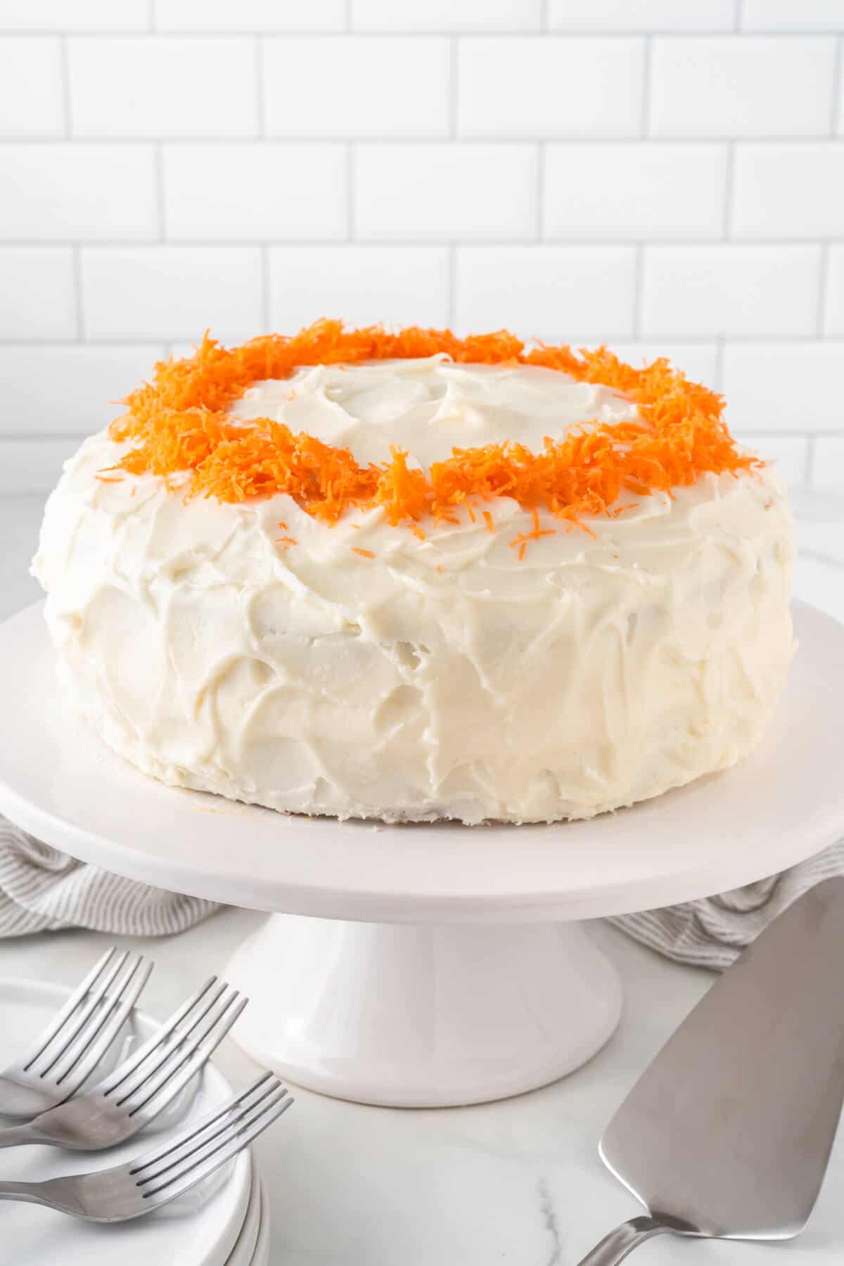 Carrot cake on a white cake stand.