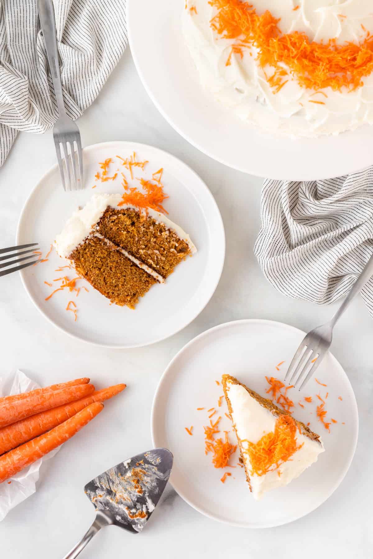 Two slices of carrot cake on plates.