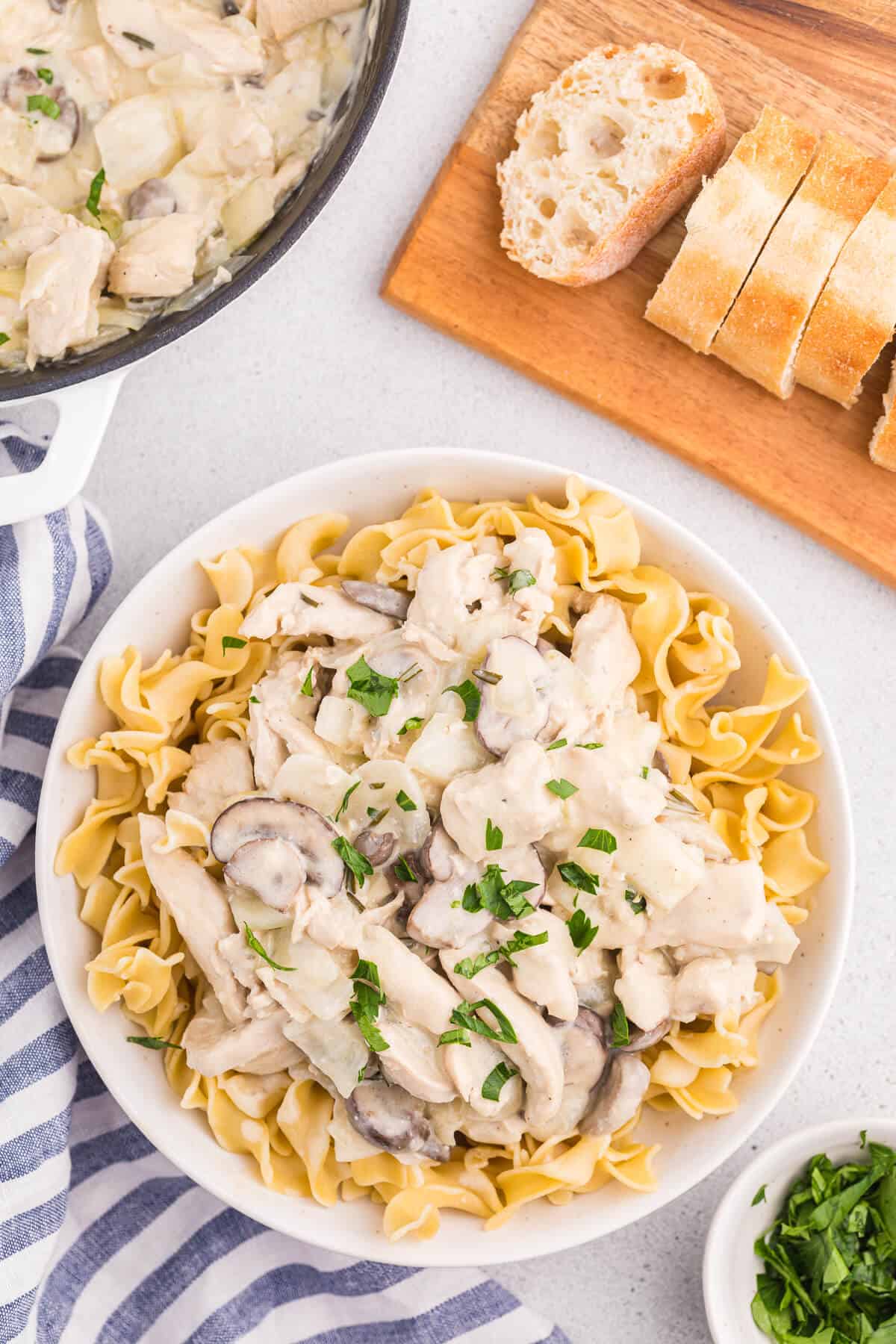 Creamy Garlic chicken with noodles in a white bowl.