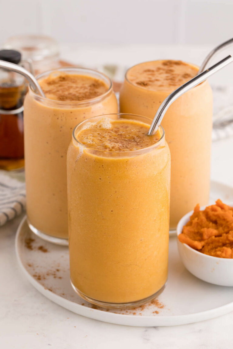 Three pumpkin pie smoothies on a plate.