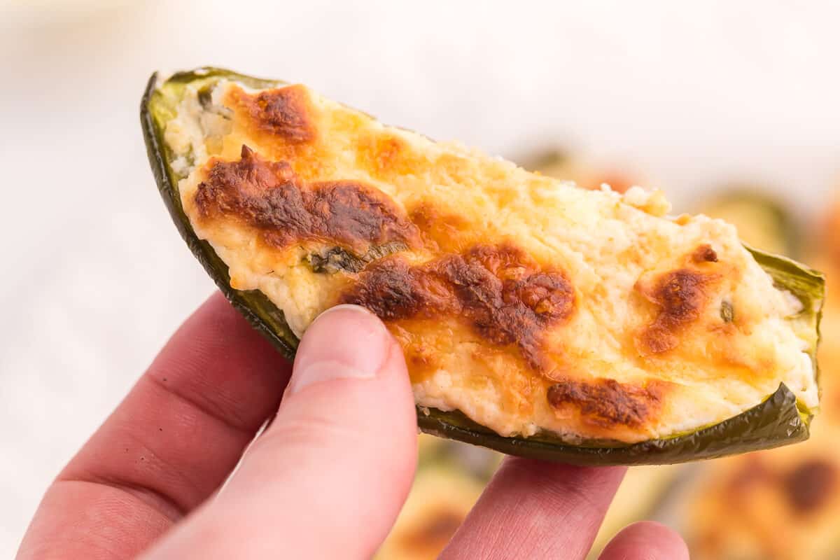 A hand holding a cheese stuffed jalapeno.