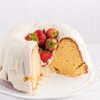 Vanilla Cream Cheese Cake on a cake stand with pieces cut out