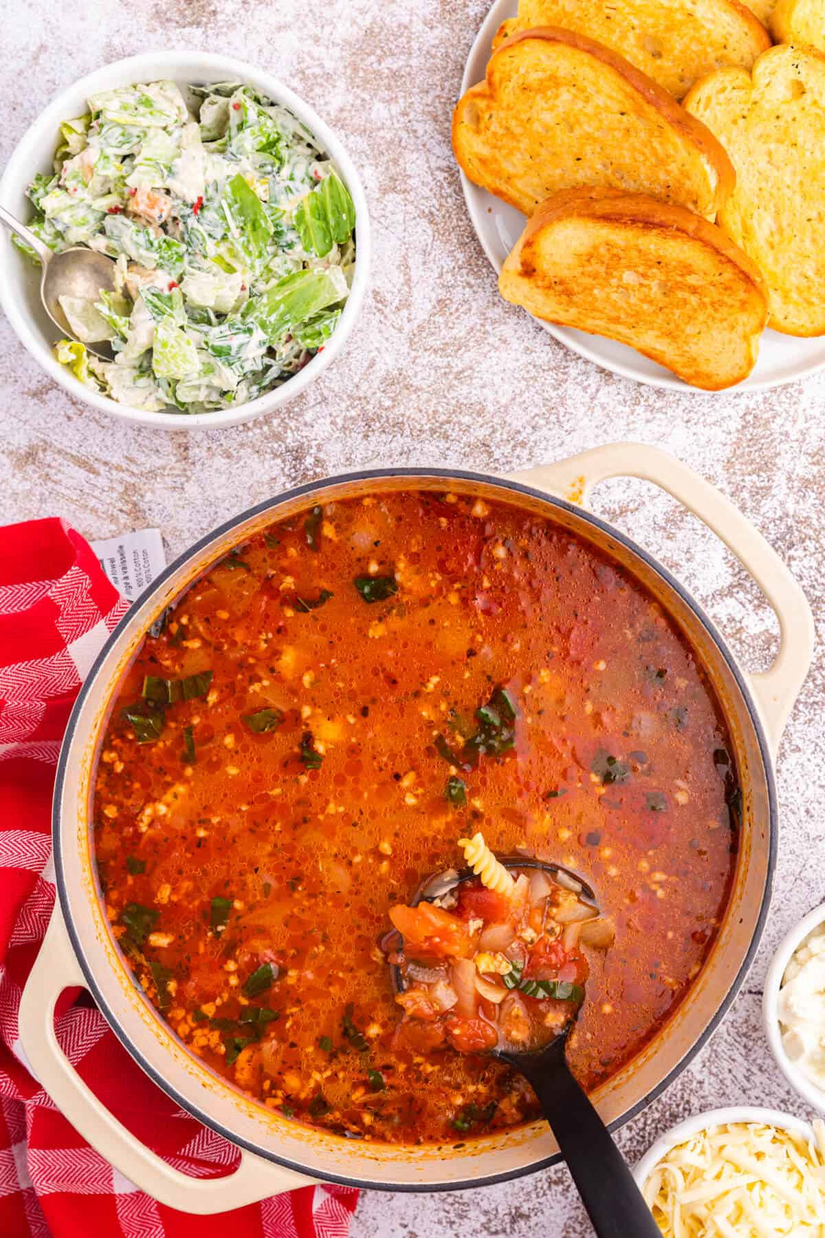 Lasagna soup in a dutch oven with a ladle.