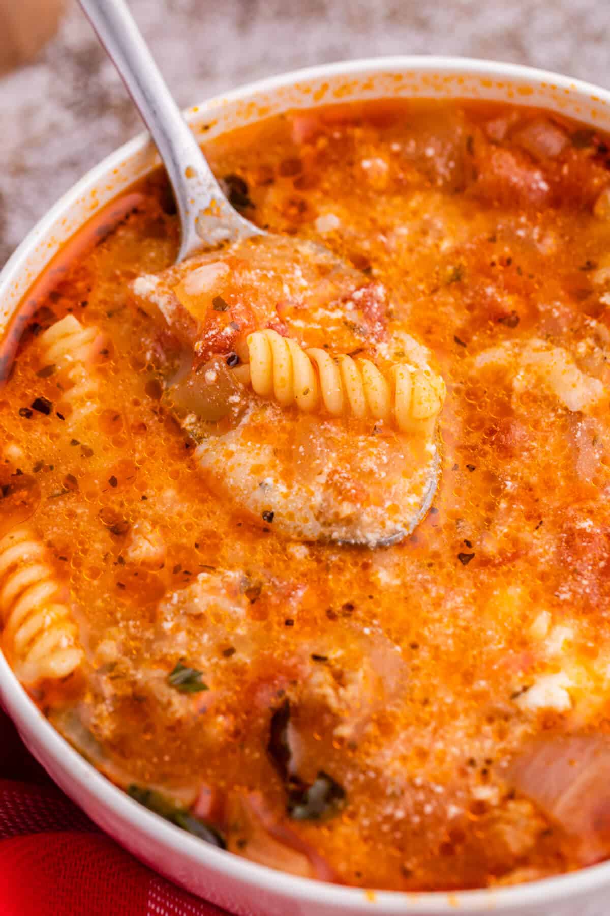 Lasagna soup in a white bowl with a spoon.