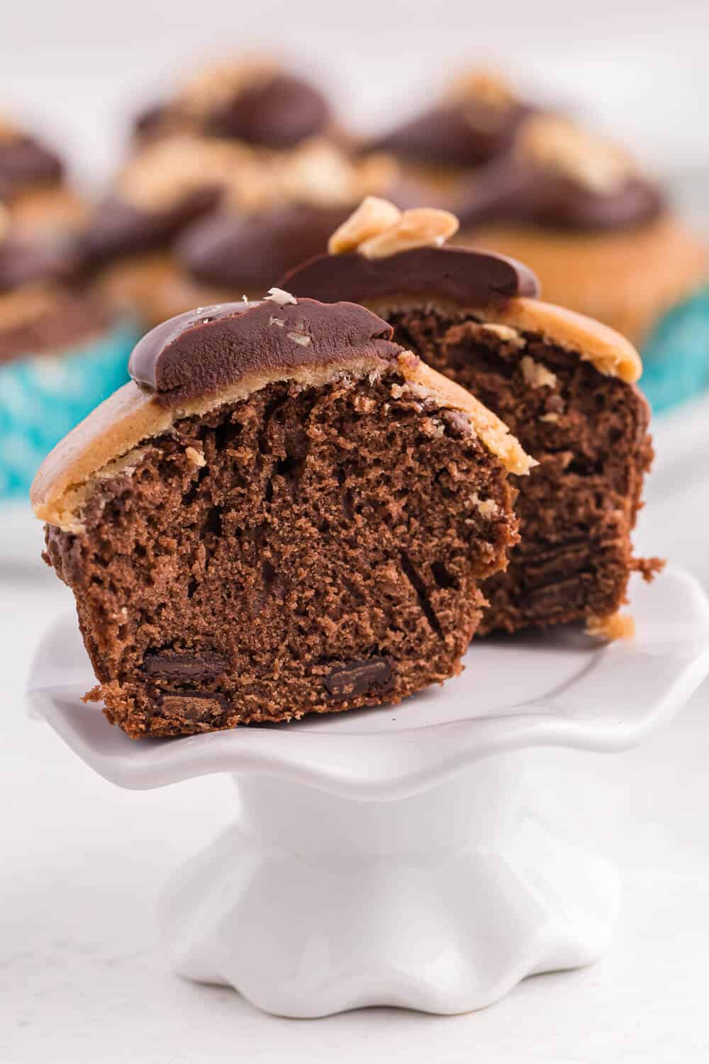 A cut peanut butter brownie cupcake on a cupcake stand