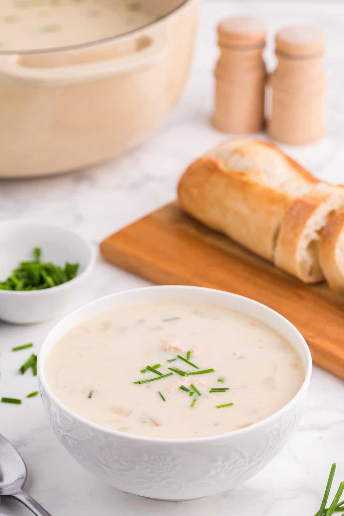 A white bowl of salmon chowder.