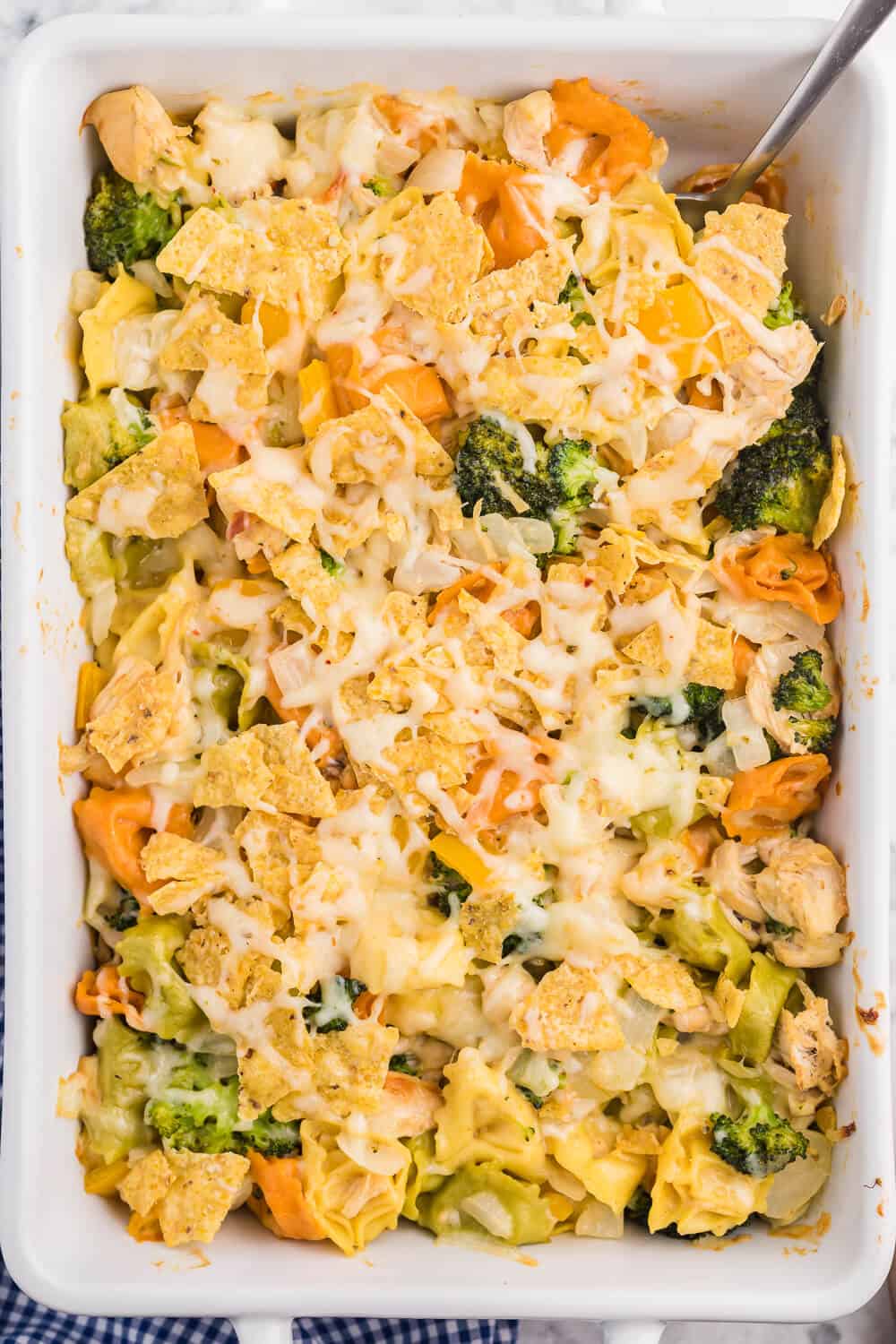 Santa Fe Chicken Tortellini Casserole - Tortellini pasta with veggies and chicken enveloped in a creamy sauce and topped with crunchy tortilla chips. An easy family dinner recipe ready in under 1 hour.