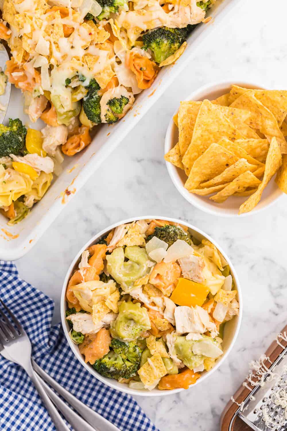 Santa Fe Chicken Tortellini Casserole - Tortellini pasta with veggies and chicken enveloped in a creamy sauce and topped with crunchy tortilla chips. An easy family dinner recipe ready in under 1 hour.