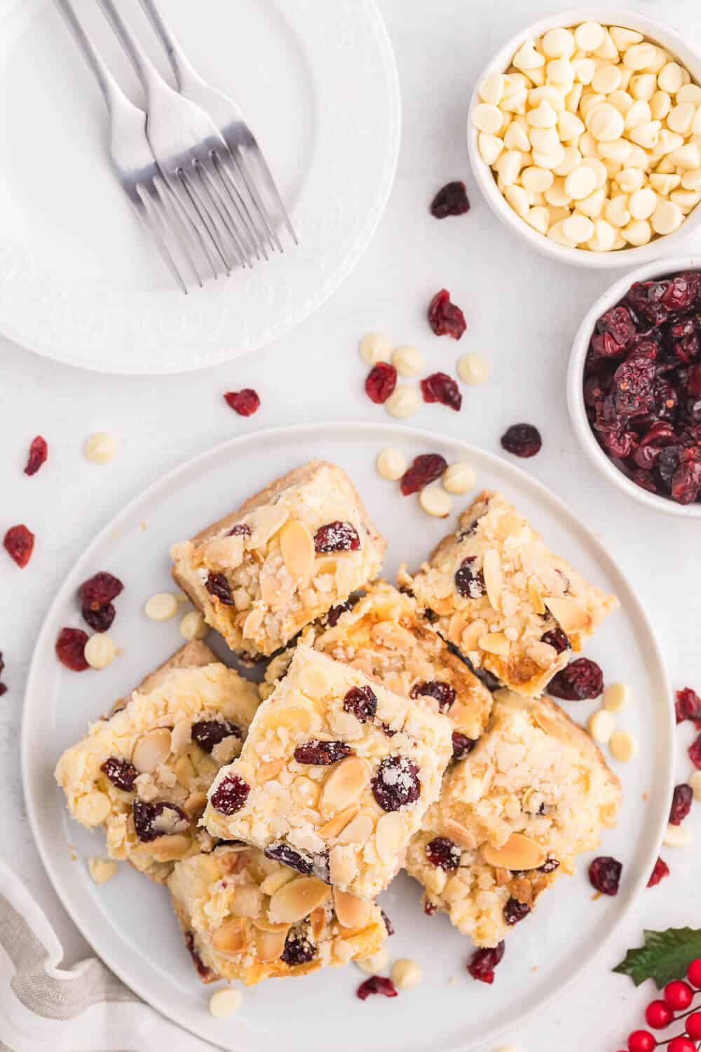 A plate of cut white chocolate cranberry cheesecake bars