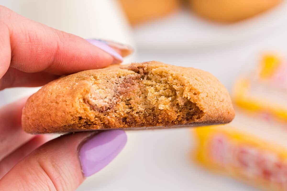 A hand holding a Coffee Crisp Cookie with a bite out of it.