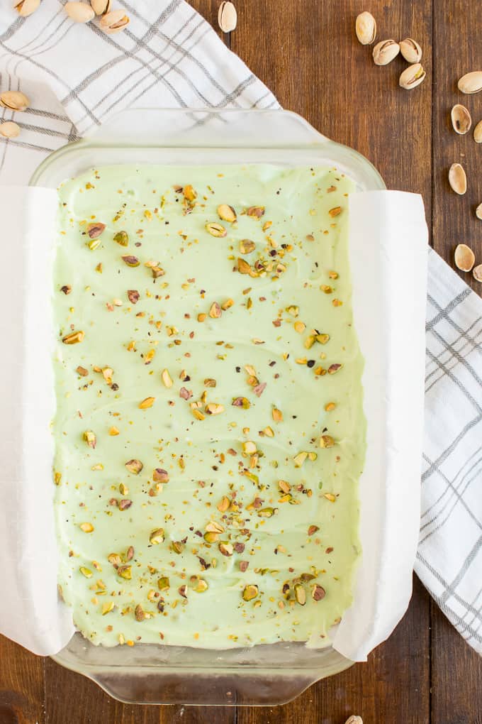 Pistachio Cream Bars - Made with a shortbread cookie base and filling that is a cross between a pudding and cheesecake. This vibrantly coloured dessert is a great make-ahead dish for entertaining. The crowd pleasing flavour of pistachio will be a winner!