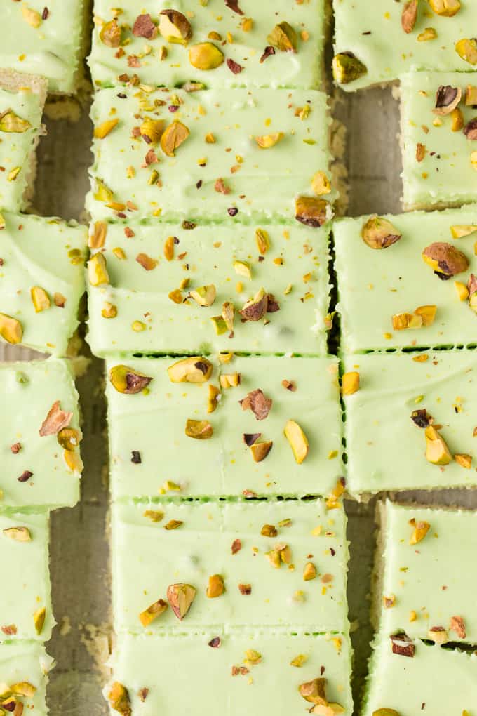 Pistachio Cream Bars - Made with a shortbread cookie base and filling that is a cross between a pudding and cheesecake. This vibrantly coloured dessert is a great make-ahead dish for entertaining. The crowd pleasing flavour of pistachio will be a winner!