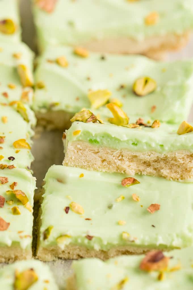 Pistachio Cream Bars - Made with a shortbread cookie base and filling that is a cross between a pudding and cheesecake. This vibrantly coloured dessert is a great make-ahead dish for entertaining. The crowd pleasing flavour of pistachio will be a winner!