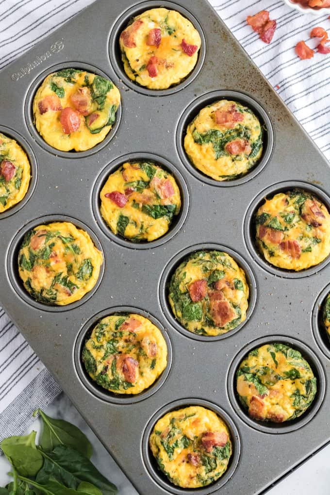 Spinach and cheese egg muffins in a muffin tin.