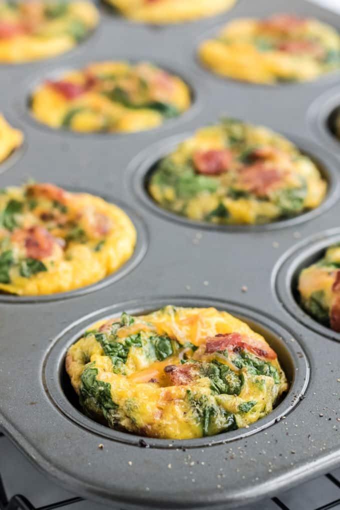 Spinach and cheese egg muffins in a muffin pan.